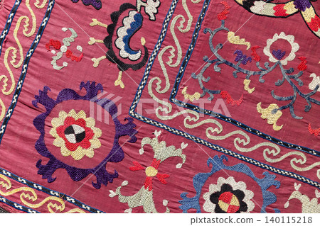 Rich magenta embroidered suzani textile featuring bold floral motifs Rich magenta embroidered suzani textile featuring bold floral motifs 140115218