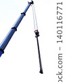 Blue crane arm vertical, boom with hanging hook against clear sky. Construction and lifting heavy building materials, large components and machinery. Construction frame 140116771