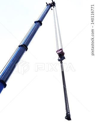 Blue crane arm vertical, boom with hanging hook against clear sky. Construction and lifting heavy building materials, large components and machinery. Construction frame 140116771