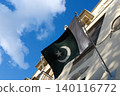 Pakistani flag swaying in the wind against blue sky and historical buildings. Flag of Pakistan. Flag day celebration concept, patriotism concept. Embassies and consulates of countries 140116772