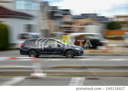 鏡頭緩緩搖攝一輛行駛在郊區的汽車 鏡頭緩緩搖攝一輛行駛在郊區的汽車 140116827