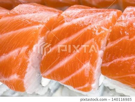 Fresh salmon nigiri sushi closeup with raw Atlantic salmon slices and traditional Japanese rice rolls Fresh salmon nigiri sushi closeup with raw Atlantic salmon slices and traditional Japanese rice rolls 140116985