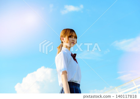 A woman in a school uniform under a blue sky A woman in a school uniform under a blue sky 140117818