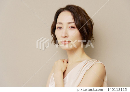 Middle-aged woman portrait brown background looking at camera Middle-aged woman portrait brown background looking at camera 140118115