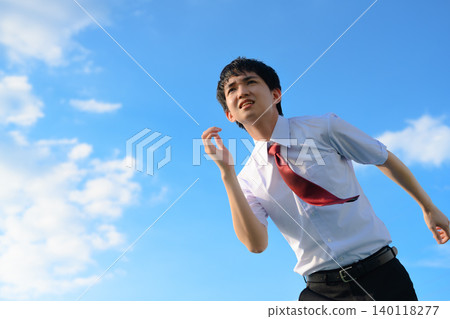 A businessman running under the blue sky A businessman running under the blue sky 140118277
