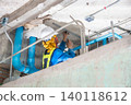 An unfinished building interior shows exposed metal electrical conduits fixed along rough concrete walls and ceilings. The room is under renovation and visible utility routing. 140118612