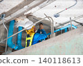 An unfinished building interior shows exposed metal electrical conduits fixed along rough concrete walls and ceilings. The room is under renovation and visible utility routing. 140118613