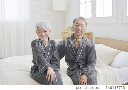 Senior couple portrait bedroom looking at camera 140118713