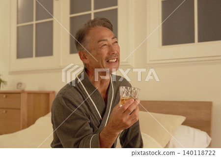 Portrait of a senior man drinking whiskey in his bedroom Portrait of a senior man drinking whiskey in his bedroom 140118722