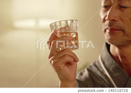 特寫鏡頭：一名男子手持一杯威士忌 140118728