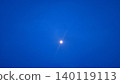 Real photograph of the moon shining in a deep blue evening sky with a calm minimalist atmosphere. 140119113