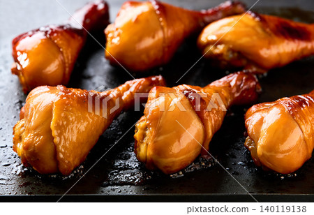 chicken drumsticks with crispy skin roasting on a grill . chicken drumsticks with crispy skin roasting on a grill . 140119138