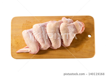 raw chicken wings on a cutting board isolated on a white background, top view. raw chicken wings on a cutting board isolated on a white background, top view. 140119168
