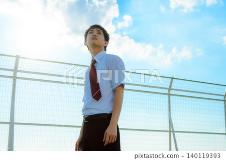 A young man in a uniform looking up at the sky 140119393