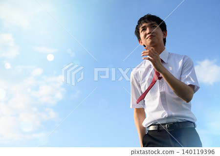 A young man looking up at the blue sky A young man looking up at the blue sky 140119396