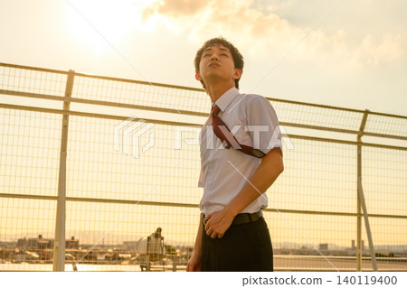 黃昏時分，一位年輕人抬頭望向天空。 140119400