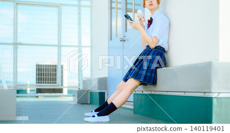 一個穿著校服的女孩正在操作她的智慧型手機 一個穿著校服的女孩正在操作她的智慧型手機 140119401