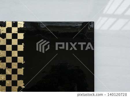 A luxurious Japanese-style material featuring a glossy black lacquer-like background and a checkered pattern of gold leaf. A luxurious Japanese-style material featuring a glossy black lacquer-like background and a checkered pattern of gold leaf. 140120728