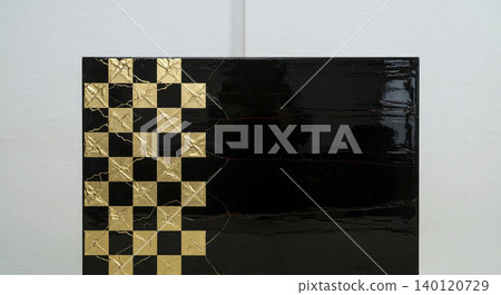 A luxurious Japanese-style material featuring a glossy black lacquer-like background and a checkered pattern of gold leaf. A luxurious Japanese-style material featuring a glossy black lacquer-like background and a checkered pattern of gold leaf. 140120729