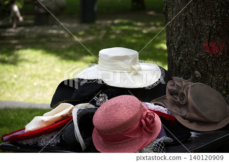 Assorted Women's Hats Stacked on Bench in Park, Vintage Summer Fashion and Outdoor Millinery Display Assorted Women's Hats Stacked on Bench in Park, Vintage Summer Fashion and Outdoor Millinery Display 140120909