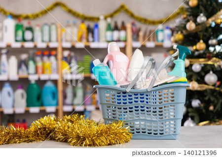 In Christmas eve, filled shopping trolley with household chemicals goods are on counter in store 140121396