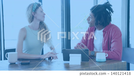 Discussing woman in sleeveless top and man in red shirt reviewing tablet papers at cafe Discussing woman in sleeveless top and man in red shirt reviewing tablet papers at cafe 140121418