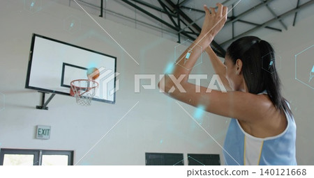 Shooting woman wearing sleeveless sports top following at gym, basketball near rim, copy space Shooting woman wearing sleeveless sports top following at gym, basketball near rim, copy space 140121668