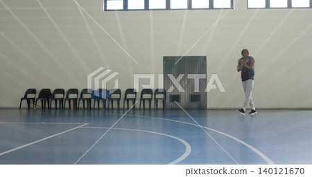 Standing man wearing vest and pants near wall in gym, with chairs, blue jacket, copy space Standing man wearing vest and pants near wall in gym, with chairs, blue jacket, copy space 140121670