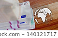 Displaying banded 50 EUR bills with straps on wooden table, showing white dotted map and globe 140121717