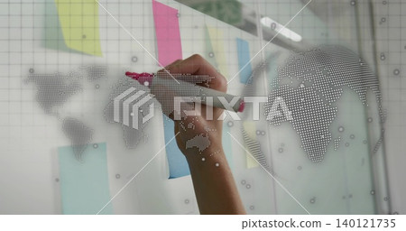 Writing right hand marking glass board at office, with pink marker, sticky notes, dotted map Writing right hand marking glass board at office, with pink marker, sticky notes, dotted map 140121735