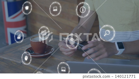 Handling small black device, man in light shirt working at cafe with laptop, tech overlays Handling small black device, man in light shirt working at cafe with laptop, tech overlays 140121771