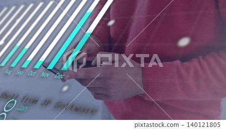 Tapping male hands in pink sweater at workspace using smartphone with holographic bar chart Tapping male hands in pink sweater at workspace using smartphone with holographic bar chart 140121805