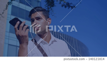 Speaking man wearing white shirt and shoulder bag in city, holding smartphone and wired earphones Speaking man wearing white shirt and shoulder bag in city, holding smartphone and wired earphones 140121814