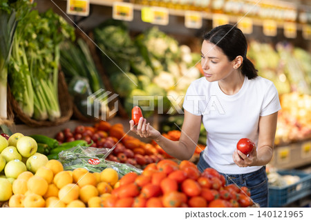 Young woman choosing red tomatoes Young woman choosing red tomatoes 140121965