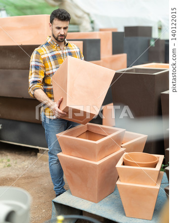 Adult man choose clay flower pots together at market 140122015