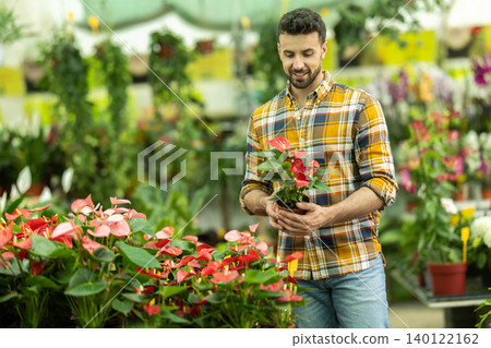 Positive man choose anthurium flowers in flower shop 140122162