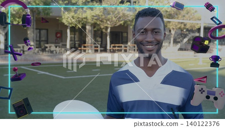 Smiling man wearing blue jersey holding white ball on sports turf, with neon gaming icons Smiling man wearing blue jersey holding white ball on sports turf, with neon gaming icons 140122376
