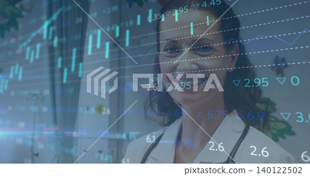 Standing doctor in lab coat, stethoscope, eyeglasses, viewing overlaid financial charts in clinic Standing doctor in lab coat, stethoscope, eyeglasses, viewing overlaid financial charts in clinic 140122502