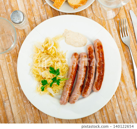 Sausages served with sauerkraut, bread and parsley Sausages served with sauerkraut, bread and parsley 140122654