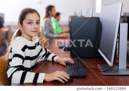 Portrait of schoolgirl at computers in university computer class Portrait of schoolgirl at computers in university computer class 140122664