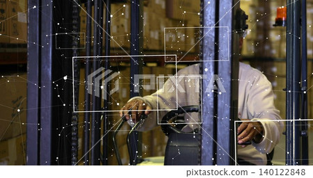 Operating forklift driver wearing light shirt navigating warehouse aisle among racks and boxes HUD 140122848