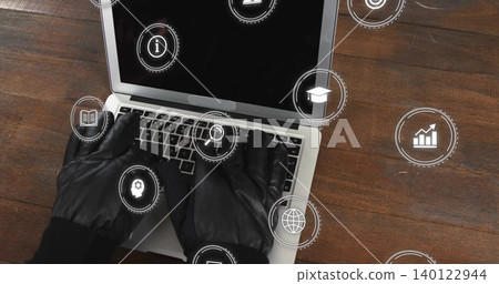 Typing black-gloved hands in dark sleeves, operating silver laptop on dark table with HUD icons Typing black-gloved hands in dark sleeves, operating silver laptop on dark table with HUD icons 140122944