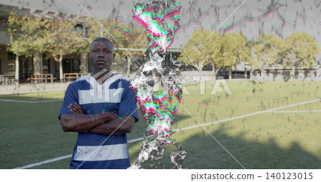 Standing man wearing striped jersey crossing arms on campus field, with glitch overlay, copy space Standing man wearing striped jersey crossing arms on campus field, with glitch overlay, copy space 140123015