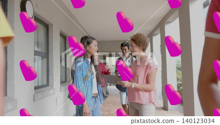 Talking student in blue plaid shirt and tutor holding tablet in school corridor, pink hearts Talking student in blue plaid shirt and tutor holding tablet in school corridor, pink hearts 140123034