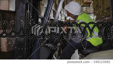 Driving forklift driver reaching controls in warehouse with helmet vest dotted overlay, copy space Driving forklift driver reaching controls in warehouse with helmet vest dotted overlay, copy space 140123092