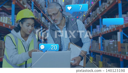 Pointing hardhat hi-vis staff viewing laptop, lead reading clip mic in warehouse with blue alerts 140123198
