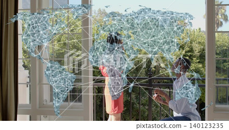 Kneeling man offering ring box to woman in coral short dress on balcony with map overlay 140123235