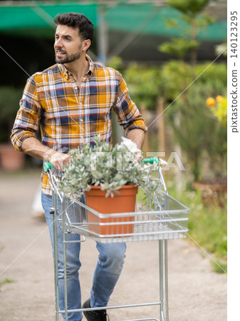 Adult man choose tree seedlings in garden supermarket Adult man choose tree seedlings in garden supermarket 140123295