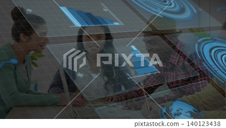 Discussing team leaning over meeting table, pointing at swatches, laptop, holographic charts, hat Discussing team leaning over meeting table, pointing at swatches, laptop, holographic charts, hat 140123438