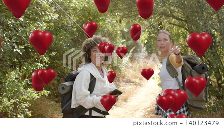 Pointing holding duo on woods dirt trail wearing hoodie packs rolled mats phone floating red hearts Pointing holding duo on woods dirt trail wearing hoodie packs rolled mats phone floating red hearts 140123479